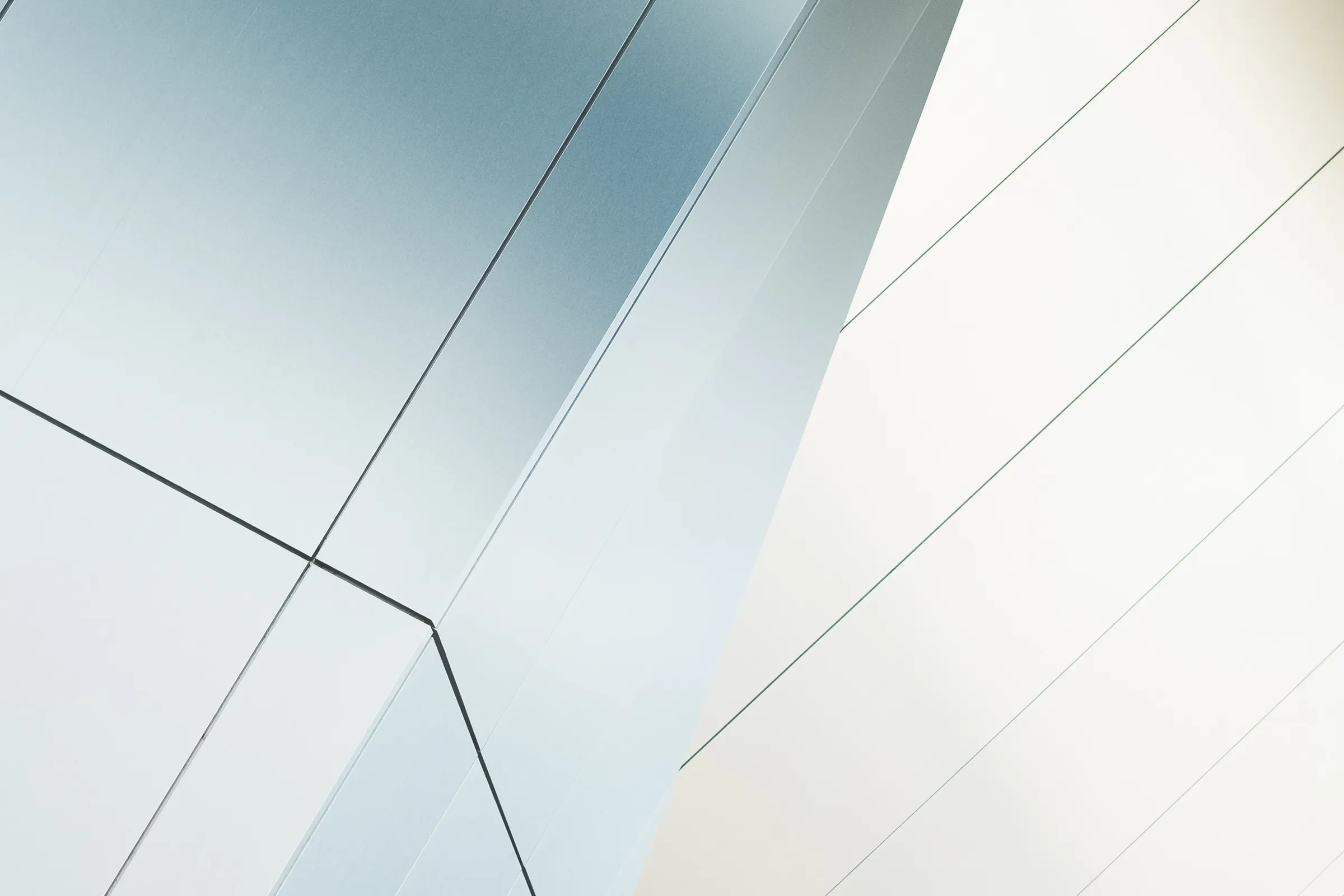 Pale silver architectural panels meeting at sharp angles.