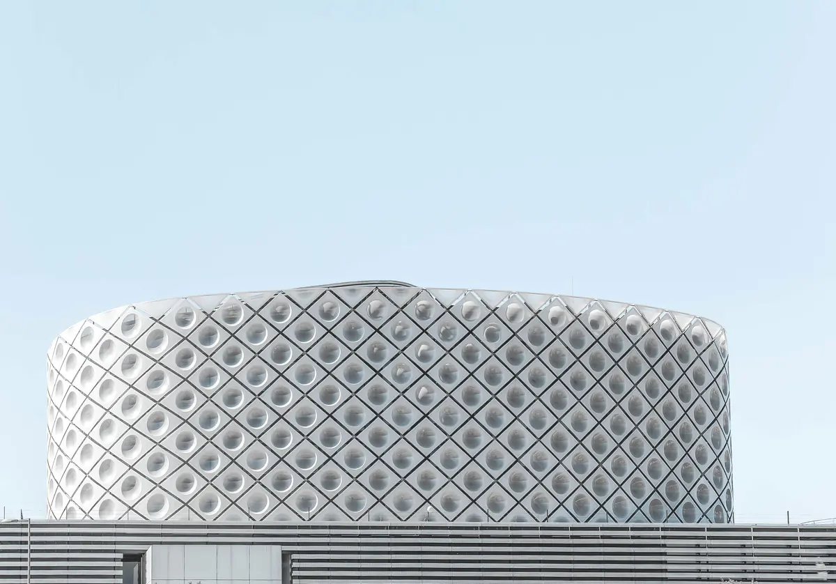 A white patterned facade against a pale sky.