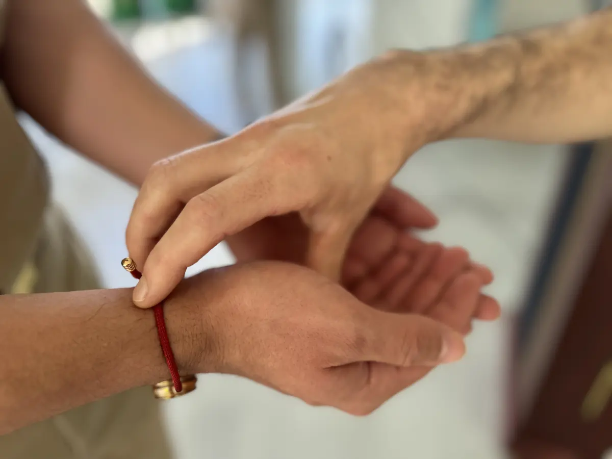 A caregiver's hands gently holding a patient's hand.