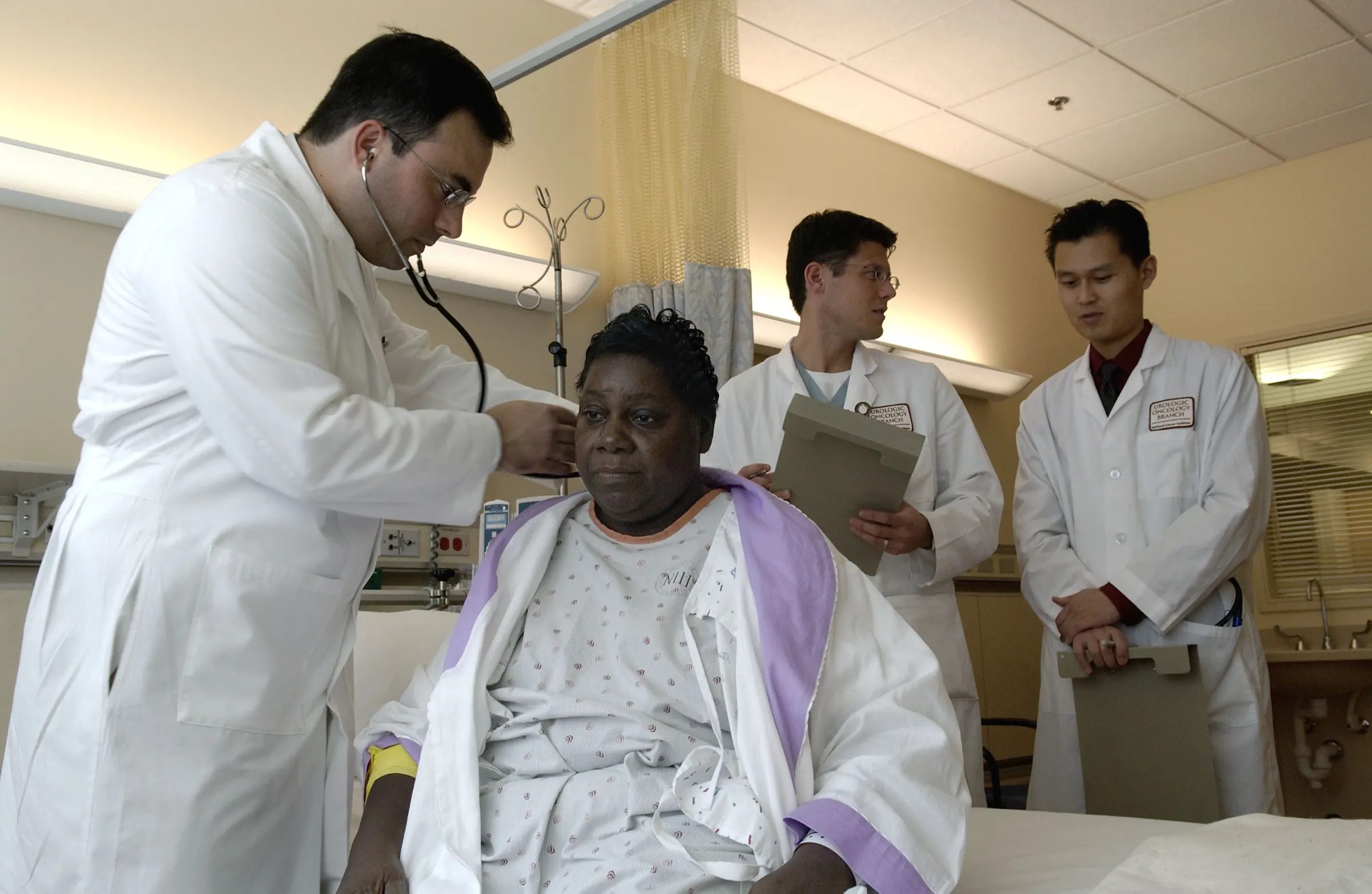 Doctors at a patient's bedside on a ward round.